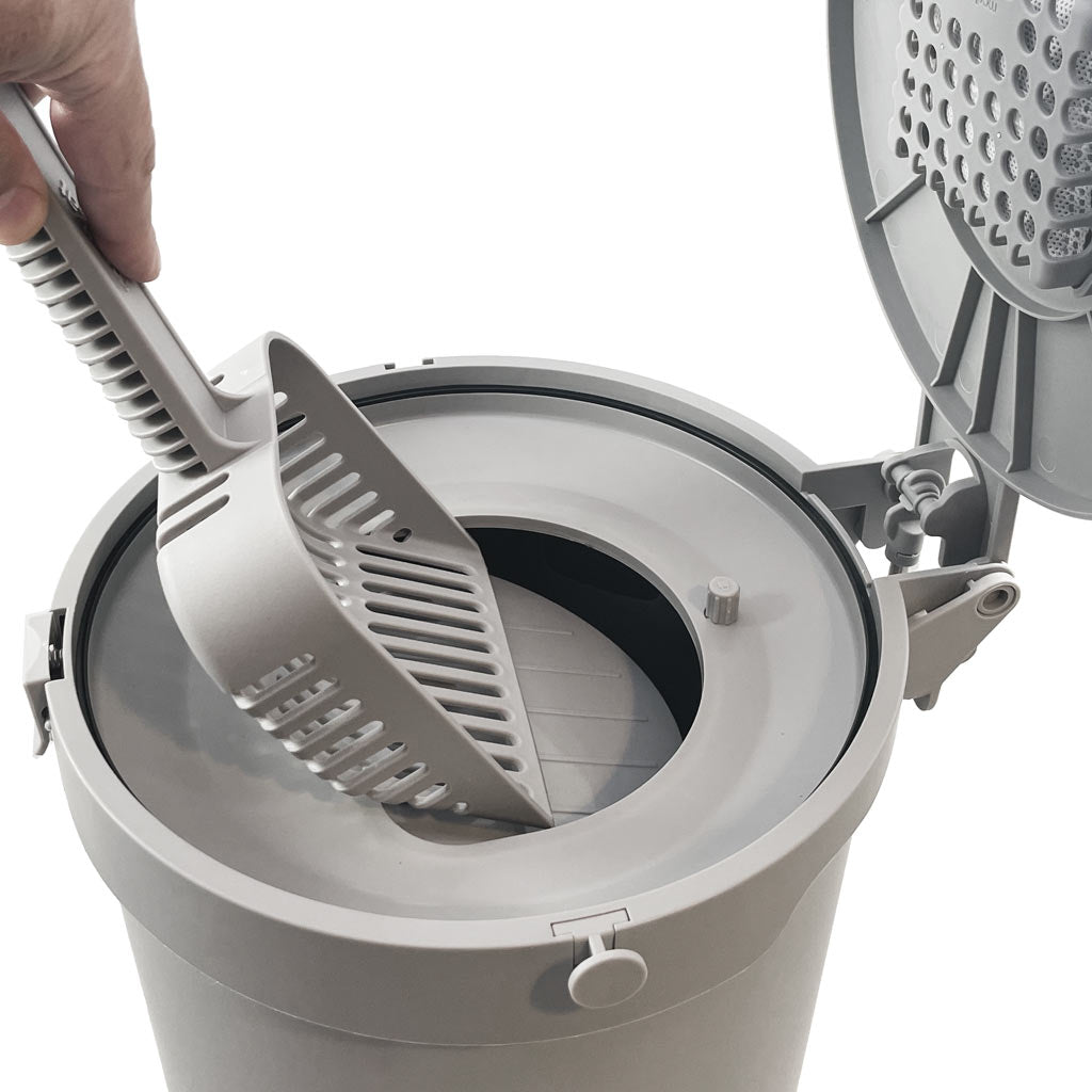 An scoop pouring cat litter into a cat litter garbage can